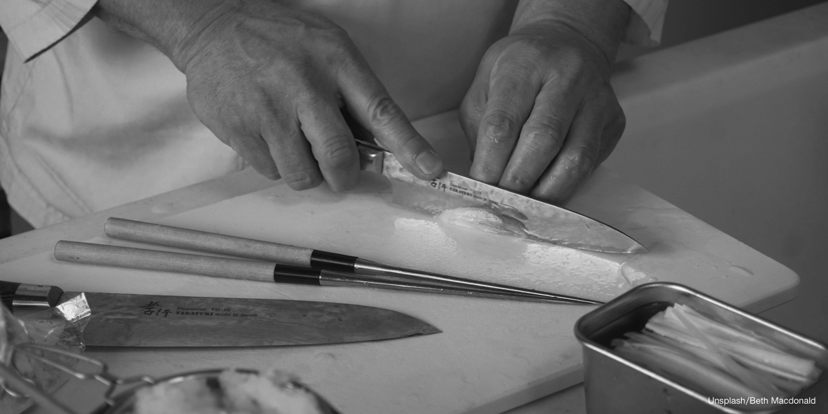 Close-up of precise ginger slicing with a Japanese knife.